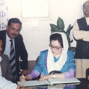 Former prime minister Benazir Bhutto writing in the visitors’ book during her visit to the Karachi Press Club. President of the club Habib Khan Ghori, its secretary Mazhar Abbas and former president Mehmood Ali Asad are also seen.